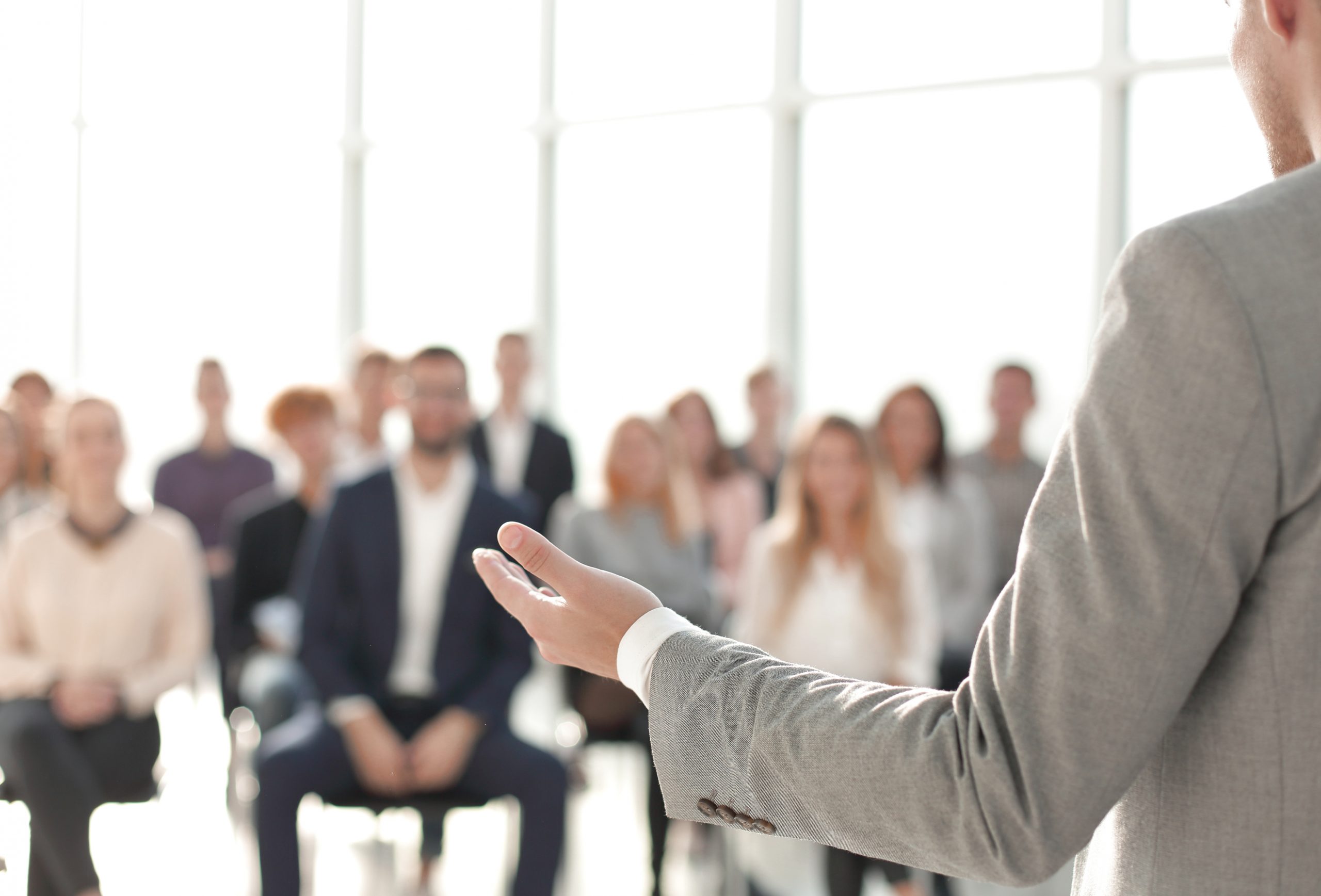 man speaking to people in chairs